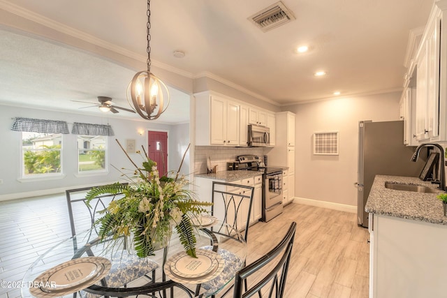 991 Dawson Dr, Deltona, FL 32725 - kitchen featuring stainless steel appliances, a sink, baseboards, tasteful backsplash, and white cabinetry