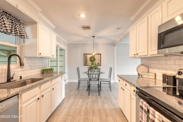 991 Dawson Dr, Deltona, FL 32725 - kitchen featuring stainless steel microwave, black range with electric stovetop, a sink, dishwasher, and backsplash