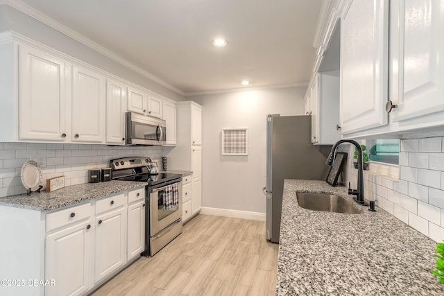 991 Dawson Dr, Deltona, FL 32725 - kitchen featuring stainless steel appliances, a sink, white cabinetry, baseboards, and backsplash