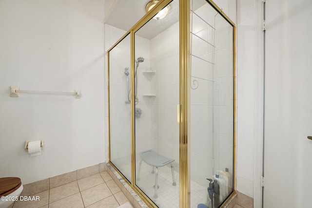 bathroom with toilet, a shower stall, and tile patterned floors