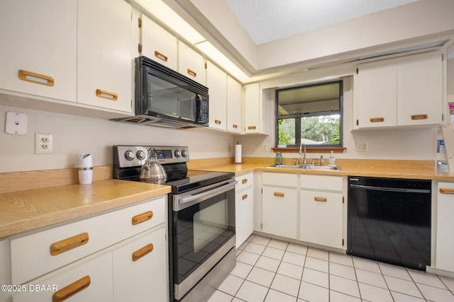 kitchen with a sink, black appliances, light countertops, and white cabinets