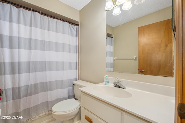 bathroom with toilet, a textured ceiling, and vanity