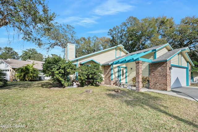 view of front of home with brick siding, a chimney, a garage, driveway, and a front lawn