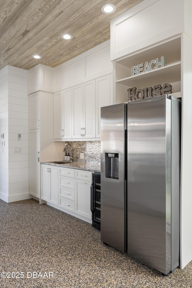 kitchen featuring wooden ceiling, recessed lighting, a sink, white cabinetry, and stainless steel fridge