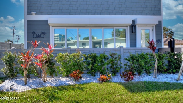 view of side of home featuring fence and a yard