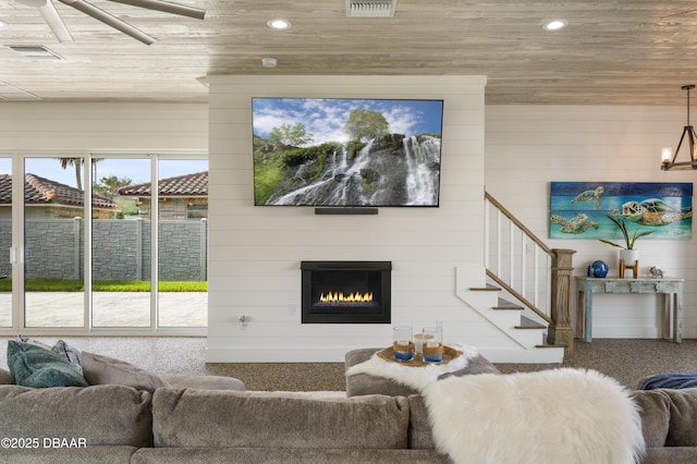 living area featuring wooden ceiling, recessed lighting, visible vents, stairs, and a glass covered fireplace