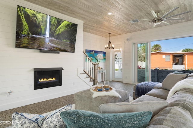 carpeted living area with wooden ceiling, recessed lighting, a large fireplace, visible vents, and stairway