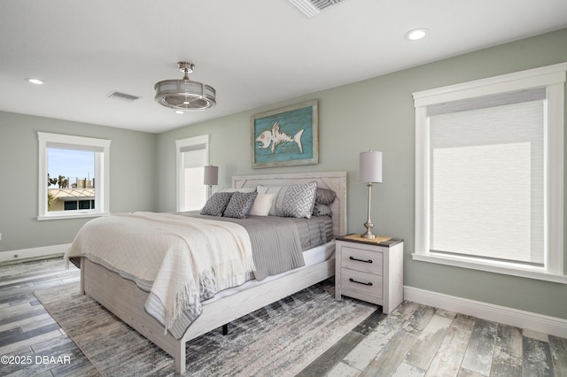 bedroom featuring baseboards, visible vents, and wood finished floors