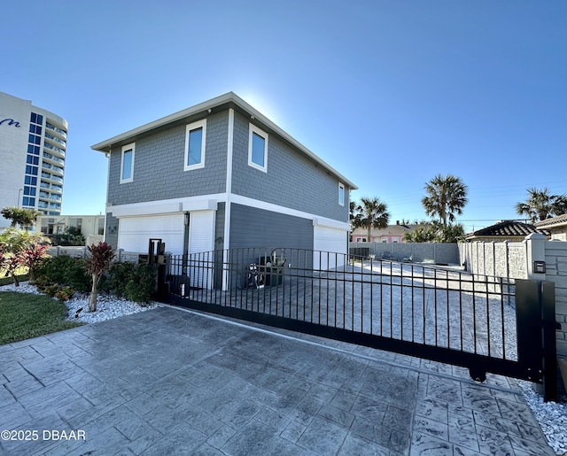 exterior space featuring driveway, a garage, and fence