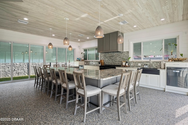 kitchen with decorative backsplash, light stone countertops, visible vents, and wooden ceiling