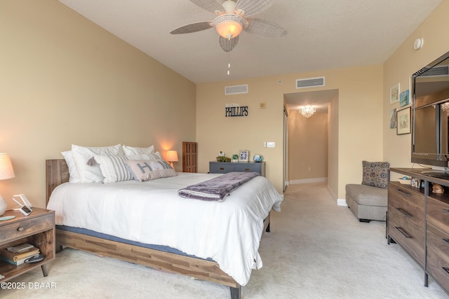 bedroom with a ceiling fan, visible vents, light carpet, and baseboards