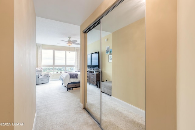 hallway with carpet floors and baseboards