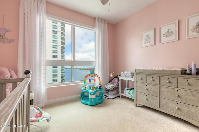 bedroom with baseboards, ceiling fan, multiple windows, and light colored carpet