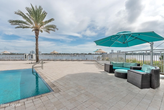 view of patio / terrace featuring a water view, fence, outdoor lounge area, and a fenced in pool