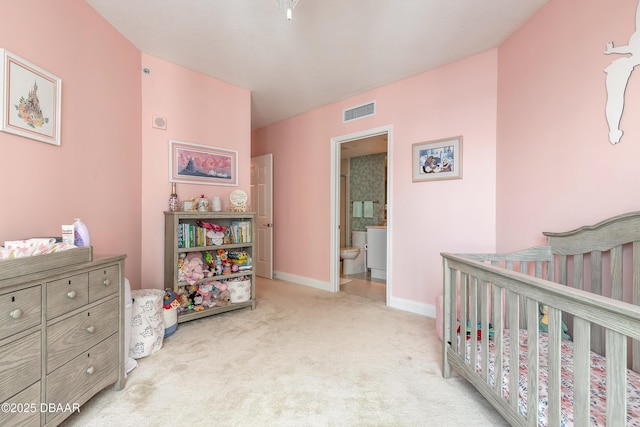 bedroom featuring a nursery area, visible vents, light carpet, and baseboards