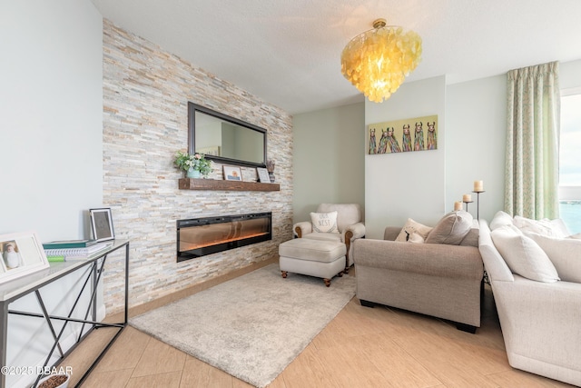 living area with a textured ceiling, a notable chandelier, a fireplace, and wood finished floors