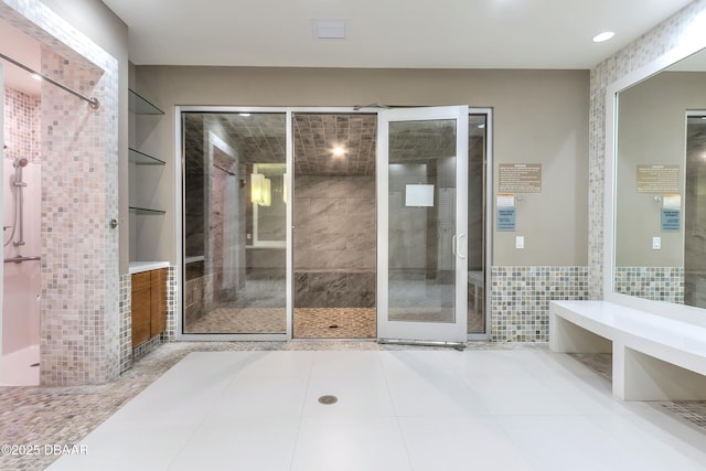 full bathroom with tile patterned flooring and tile walls