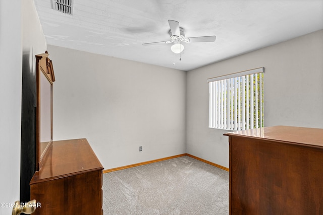 unfurnished bedroom featuring baseboards, carpet, and a ceiling fan