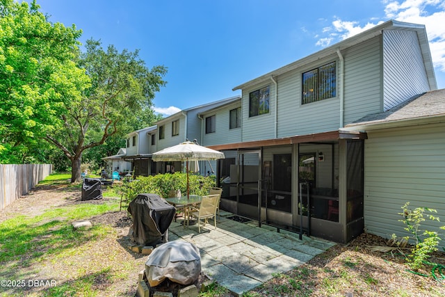 rear view of property with a sunroom, a patio area, and fence