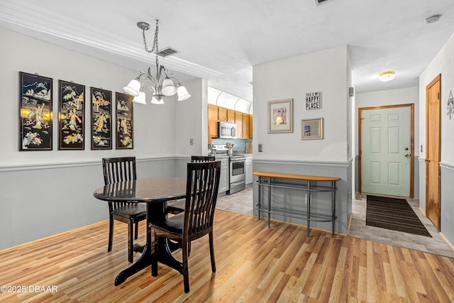 dining area featuring a chandelier and light wood-style flooring