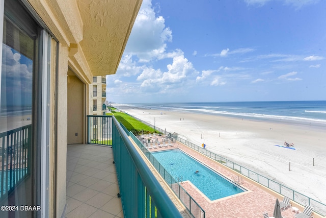 balcony with a water view and a beach view