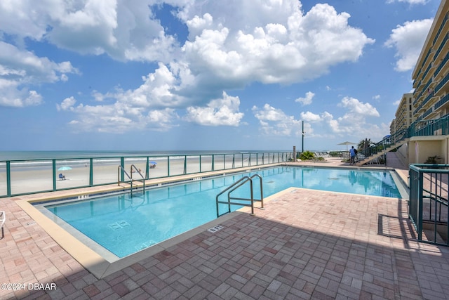 view of pool with a view of the beach and a water view