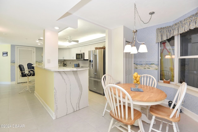 dining space featuring ceiling fan with notable chandelier and light tile patterned flooring