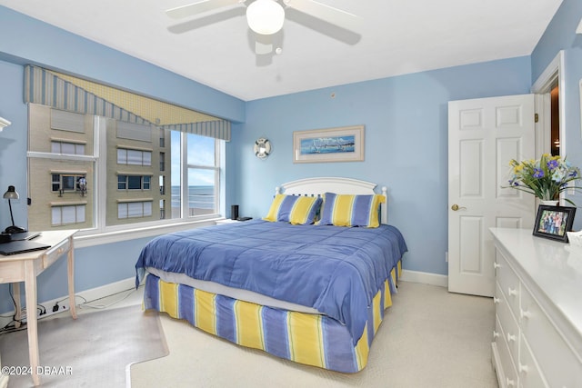 bedroom featuring ceiling fan and a water view