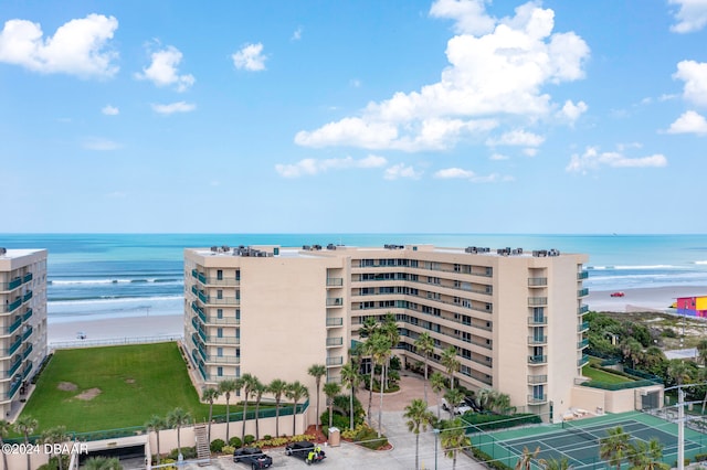 view of building exterior with a beach view and a water view