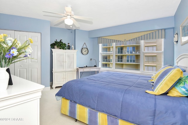 bedroom featuring a closet, light colored carpet, and ceiling fan