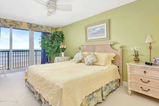 bedroom featuring access to outside, a water view, light carpet, and ceiling fan