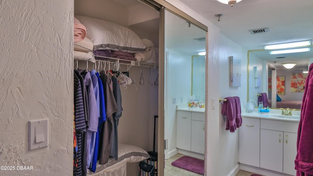 4139 S Atlantic Ave Unit B204, New Smyrna Beach, FL 32169 - bathroom featuring vanity, a spacious closet, and tile patterned floors