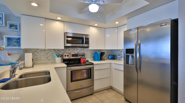 4139 S Atlantic Ave Unit B204, New Smyrna Beach, FL 32169 - kitchen featuring appliances with stainless steel finishes, white cabinetry, light countertops, light tile patterned floors, and tasteful backsplash