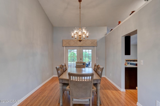 dining room featuring light wood-style flooring, baseboards, a chandelier, and french doors