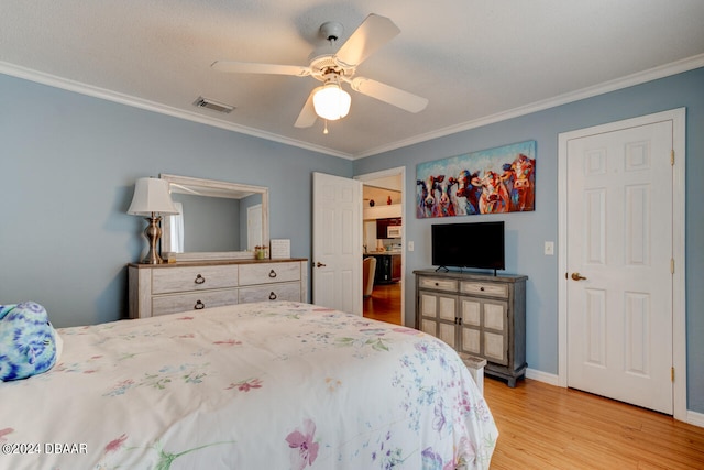 bedroom with light wood-style floors, ceiling fan, visible vents, and crown molding