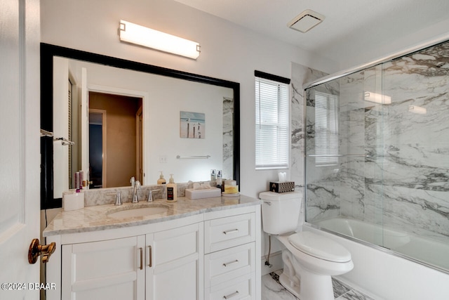 bathroom with marble finish floor, enclosed tub / shower combo, vanity, and toilet