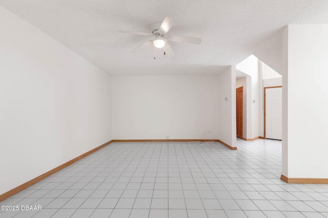 empty room with light tile patterned floors, baseboards, a ceiling fan, and a textured ceiling