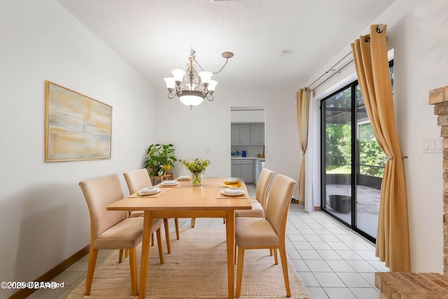 dining room featuring a chandelier, light tile patterned floors, and baseboards