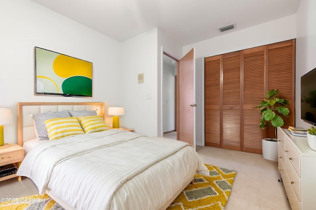 bedroom with light carpet, a closet, and visible vents