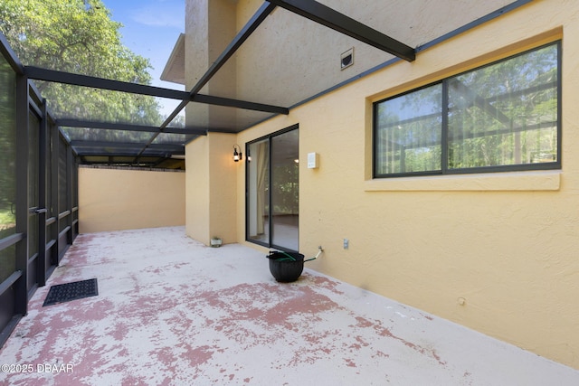 view of patio featuring visible vents and glass enclosure