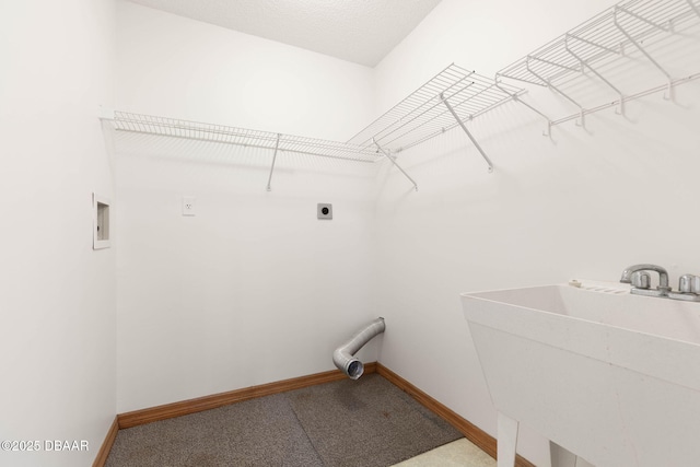 laundry room featuring laundry area, hookup for an electric dryer, a sink, and baseboards