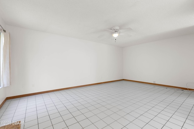 unfurnished room with ceiling fan, baseboards, and a textured ceiling