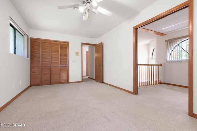 unfurnished bedroom featuring a closet, carpet flooring, baseboards, and a ceiling fan