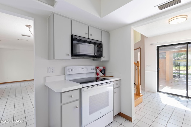 kitchen featuring visible vents, light countertops, black microwave, electric range, and light tile patterned flooring