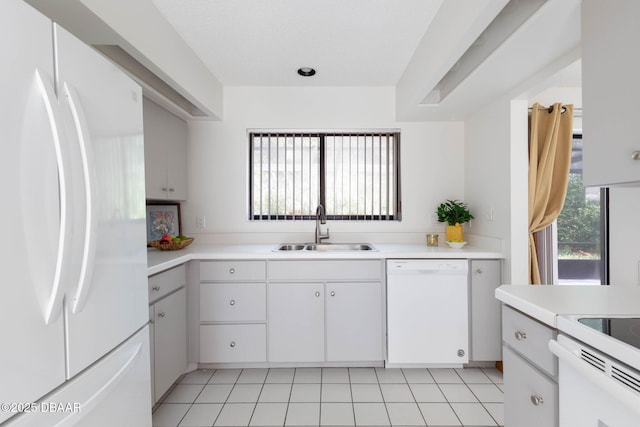 kitchen featuring light countertops, white cabinetry, a sink, and white appliances