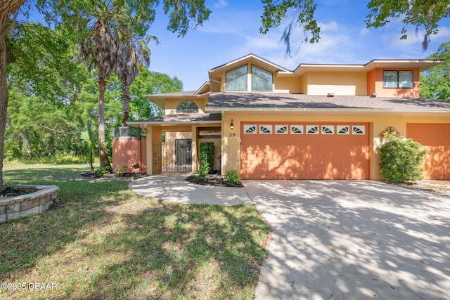 view of front of home featuring a garage, stucco siding, a front yard, a shingled roof, and driveway
