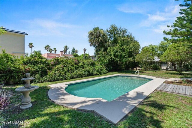 view of pool with a lawn