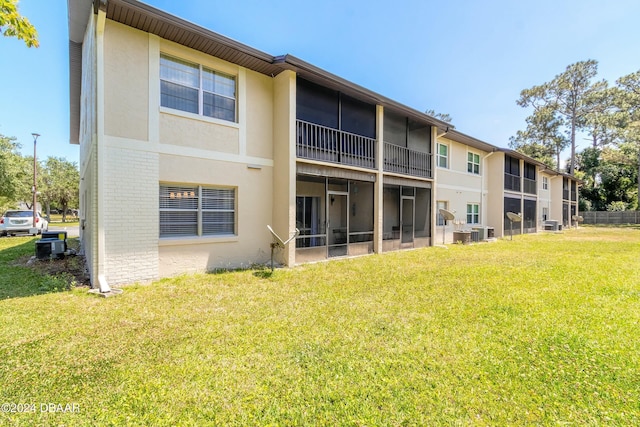 415 Banana Cay Dr Unit F, South Daytona, FL 32119 - back of property featuring brick siding, a lawn, stucco siding, and cooling unit