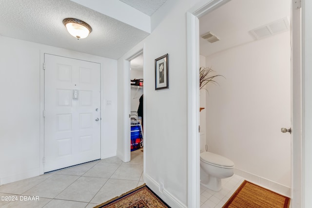 tiled foyer with a textured ceiling