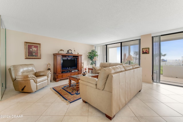 living room featuring expansive windows, light tile patterned flooring, and a textured ceiling